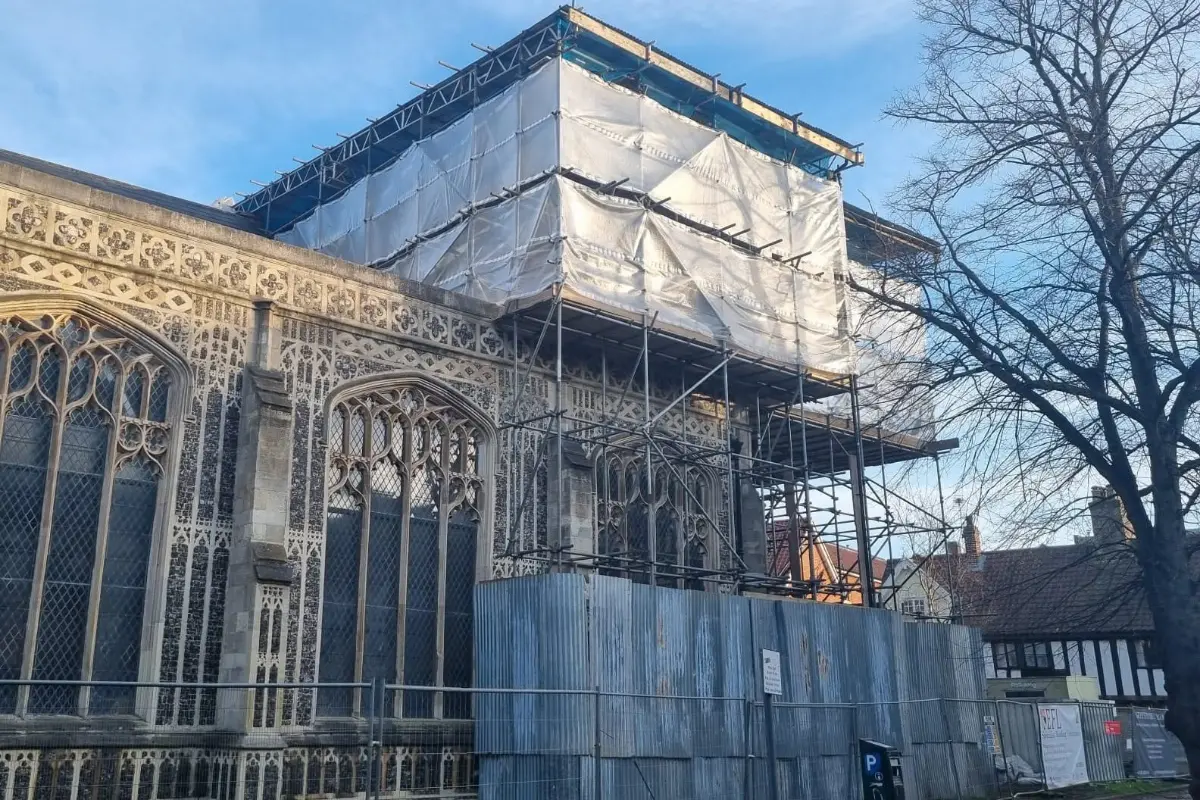 Scaffolding and protective sheeting around a historic building during restoration work